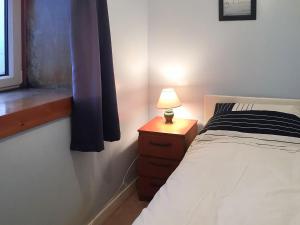 a bedroom with a bed and a table with a lamp at Tigh Mairi in Tarbert +4 photos