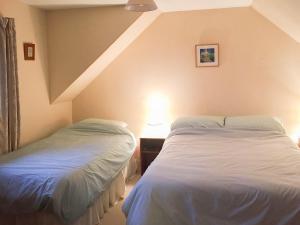 two beds sitting next to each other in a bedroom at Tigh Mairi in Tarbert
