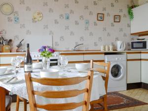 a kitchen with a table and a washing machine at Tigh Mairi in Tarbert