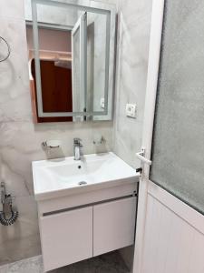 a bathroom with a white sink and a mirror at City & Sea Hideout in Himare