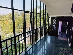 a room with a balcony with a large window at Homey - vythiri bus station in Vythiri