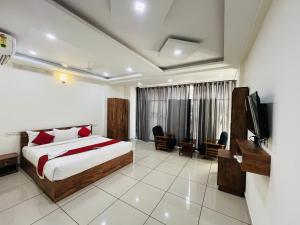 a bedroom with a bed and a television in it at Homey - vythiri bus station in Vythiri