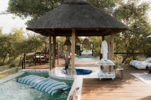 a pool with a gazebo next to a swimming pool at Maroelani Lodge- Greater Kruger Private Reserve in Hoedspruit