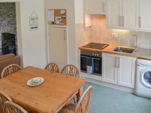 a kitchen with a wooden table and a dining room at 7 Quarrymans Cottage in Wadebridge