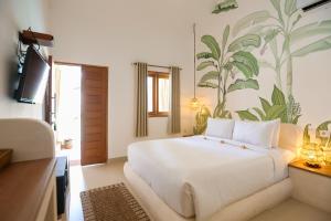 a bedroom with a large white bed with a mural at Green Banana in Gili Trawangan