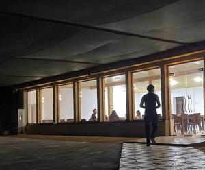 a person standing in a room looking out of windows at Aydarkul Beach in Taldy