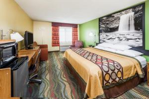 a hotel room with a bed and a flat screen tv at Super 8 by Wyndham Jacksonville in Jacksonville