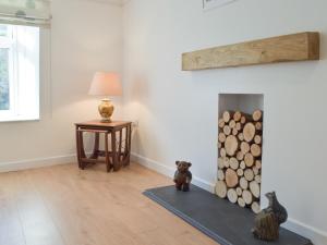 a living room with a fireplace and a table with a lamp at Snowdrop Cottage in Fishguard
