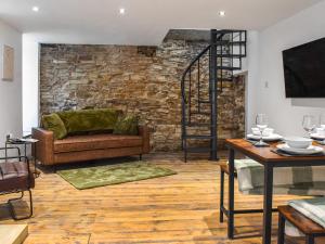 a living room with a couch and a brick wall at Ye Olde Mottram Chip Shop in Glossop