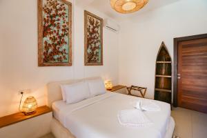 a bedroom with a white bed with a bow on it at Green Banana in Gili Trawangan +38 photos
