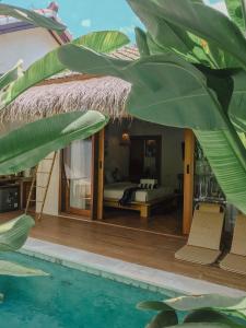 a bedroom with a bed and a swimming pool at RATU Village - Luxury Island Apartment & Private Villa Gili Air in Gili Islands
