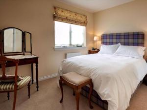 a bedroom with a bed and a desk and a mirror at Grant Crescent in Dornoch