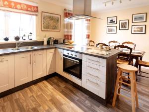 a kitchen with white cabinets and a sink at Grant Crescent in Dornoch