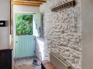 a hallway with a door and a stone wall at The Glen in Devils Bridge