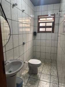 a bathroom with a toilet and a sink at Kitnet Estrela do Mar in Peruíbe