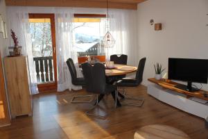 a dining room with a table and chairs and a television at Bergflügel Fewo Allgäu, Schwimmbad, Sauna, Skilift in Missen-Wilhams