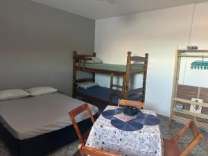 a room with a bed and a table and chairs at Kitnet Estrela do Mar in Peruíbe +19 photos