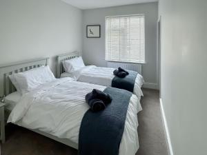 two beds in a bedroom with towels on them at April House in Amble