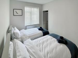 two beds in a bedroom with white walls at April House in Amble +6 photos