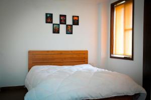 a bedroom with a white bed and a window at Echoes of Doon in Rājpur