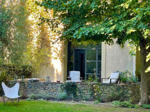 two white chairs sitting in front of a house at Le Pavillon Du Regisseur in Val-de-Dagne