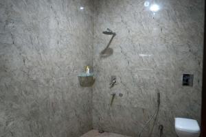 a bathroom with a shower with a toilet in it at Echoes of Doon in Rājpur +18 photos