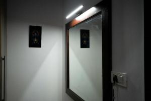 a mirror in a bathroom with two pictures on the wall at Echoes of Doon in Rājpur