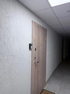 a wooden door in a room with a wall at EVA apartment in Marijampolė