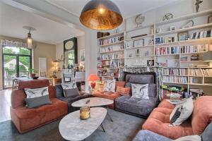 a living room with a lot of bookshelves at Le jardin des secrets in Namur