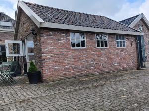 a brick house with a brick driveway at Theehus in Steggerda