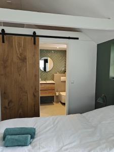 a bedroom with a white bed and a bathroom at Theehus in Steggerda