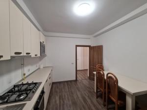 a kitchen with white cabinets and a stove top oven at Rădăuți Residence 2 in Rădăuţi