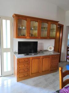 a wooden cabinet with a television on top of it at Su Muscadeddu in Tertenìa