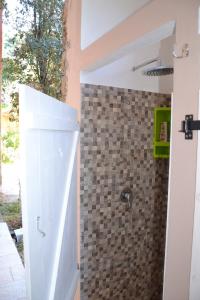 a bathroom with a shower with a tiled wall at Su Muscadeddu in Tertenìa +27 photos