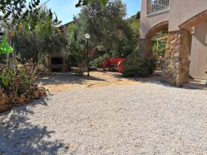 a driveway of a house with a red car parked at Su Muscadeddu in Tertenìa