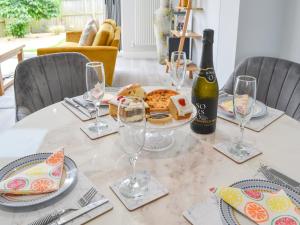 a table with a plate of food and a bottle of wine at Poppys' Place in Sewerby