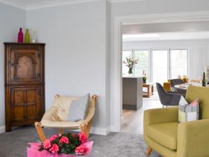 a living room with two chairs and a table with flowers at Poppys' Place in Sewerby