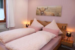 a bedroom with two beds and a picture of a bull at Bergflügel Fewo Allgäu, Schwimmbad, Sauna, Skilift in Missen-Wilhams +33 photos