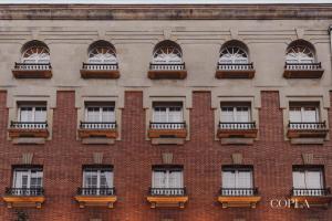 a facade of a brick building with windows and balconies at Copla Bilbao in Bilbao