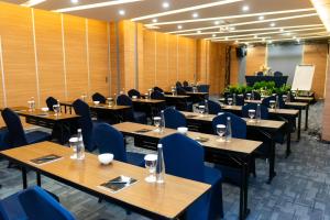 a dining room with wooden tables and blue chairs at Azana Style Hotel Tulungagung in Tulungagung +37 photos