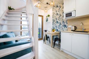 a small kitchen with a spiral staircase in a tiny house at Silver Forest in Szczecin