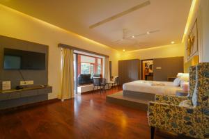 a bedroom with a bed and a television and a couch at Palm Cove Resort And Spa in Jāmb