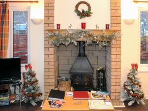 a living room with a fireplace with christmas trees at Holly Lodge in Aviemore