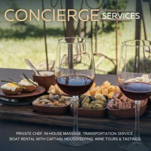 two glasses of wine sitting on a table with food at Endless Sunset with Concierge Services in Marble Falls