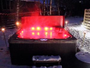 a hot tub with lights in the snow at night at Holly Lodge in Aviemore +9 photos