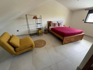 a bedroom with a bed and a couch and a chair at Ô Ti' Lodge Vanilla in Bras-Panon +17 photos