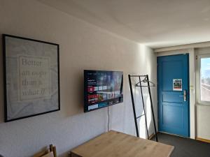 a room with a table and a blue door at Sonniges Studio mit Aussicht in Oberegg