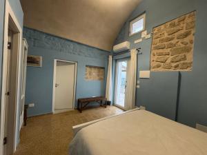 a bedroom with a bed with blue walls and a window at Il Panorama di Ercole in Monte di Procida