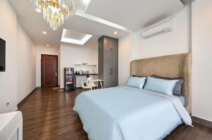 a bedroom with a large white bed and a chandelier at M Home Riverside in Ho Chi Minh City