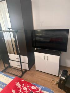 a living room with a television and white cabinets at Kay Borsa in Alba Iulia